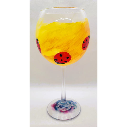 Hand-painted 18oz wine glass with yellow bowl and repeating red ladybug design by Amy Bridges