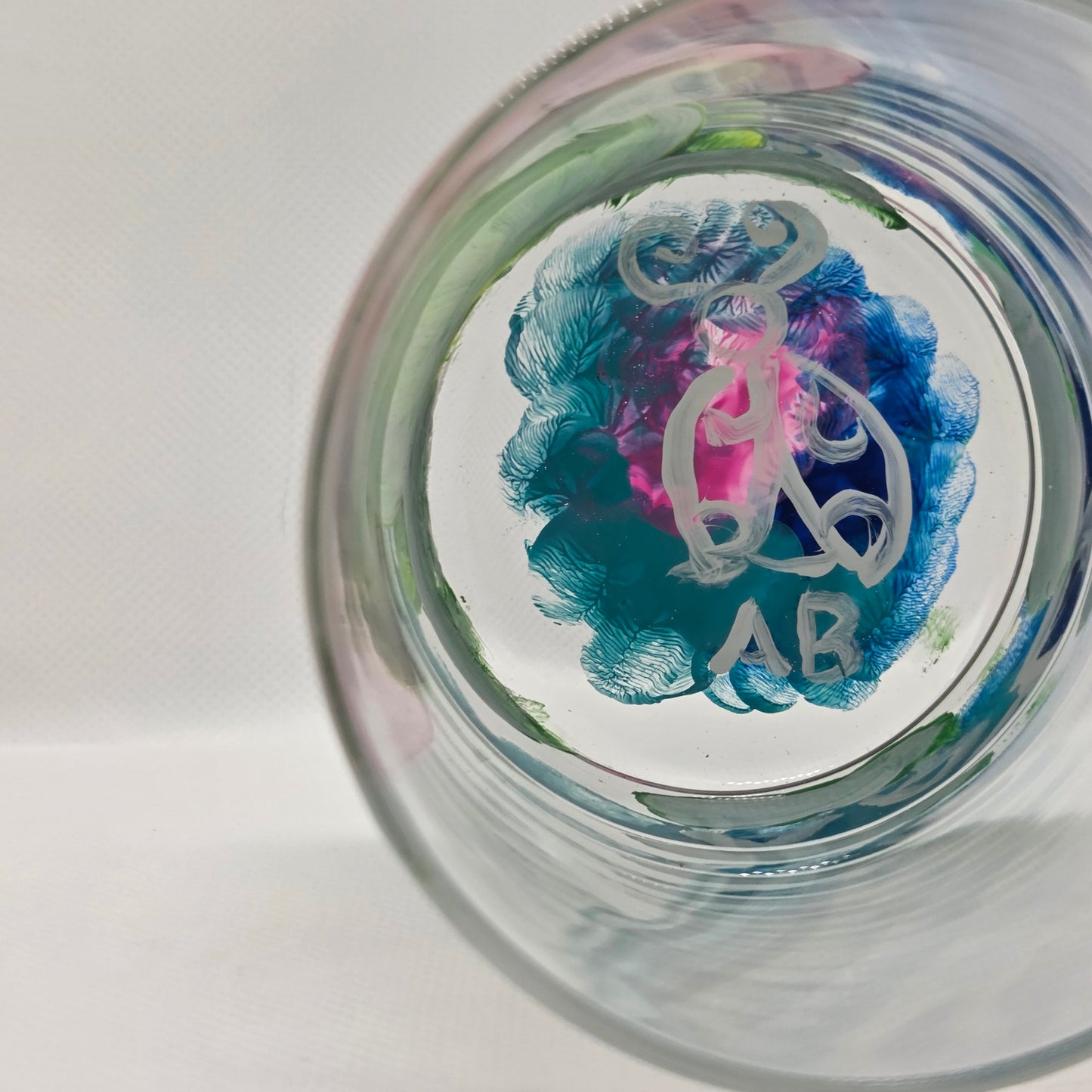 Hand-painted 11 oz highball glass featuring a whimsical frog sitting on a lily pad wearing a red mushroom hat with lily pad details wrapping around the glass.