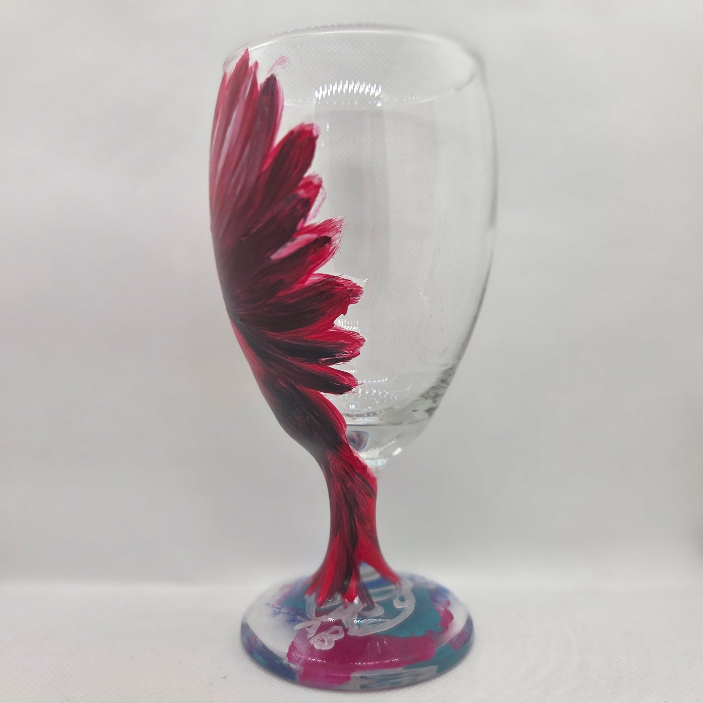 Hand-painted glass featuring a red male cardinal in flight looking down as he approaches his landing perch