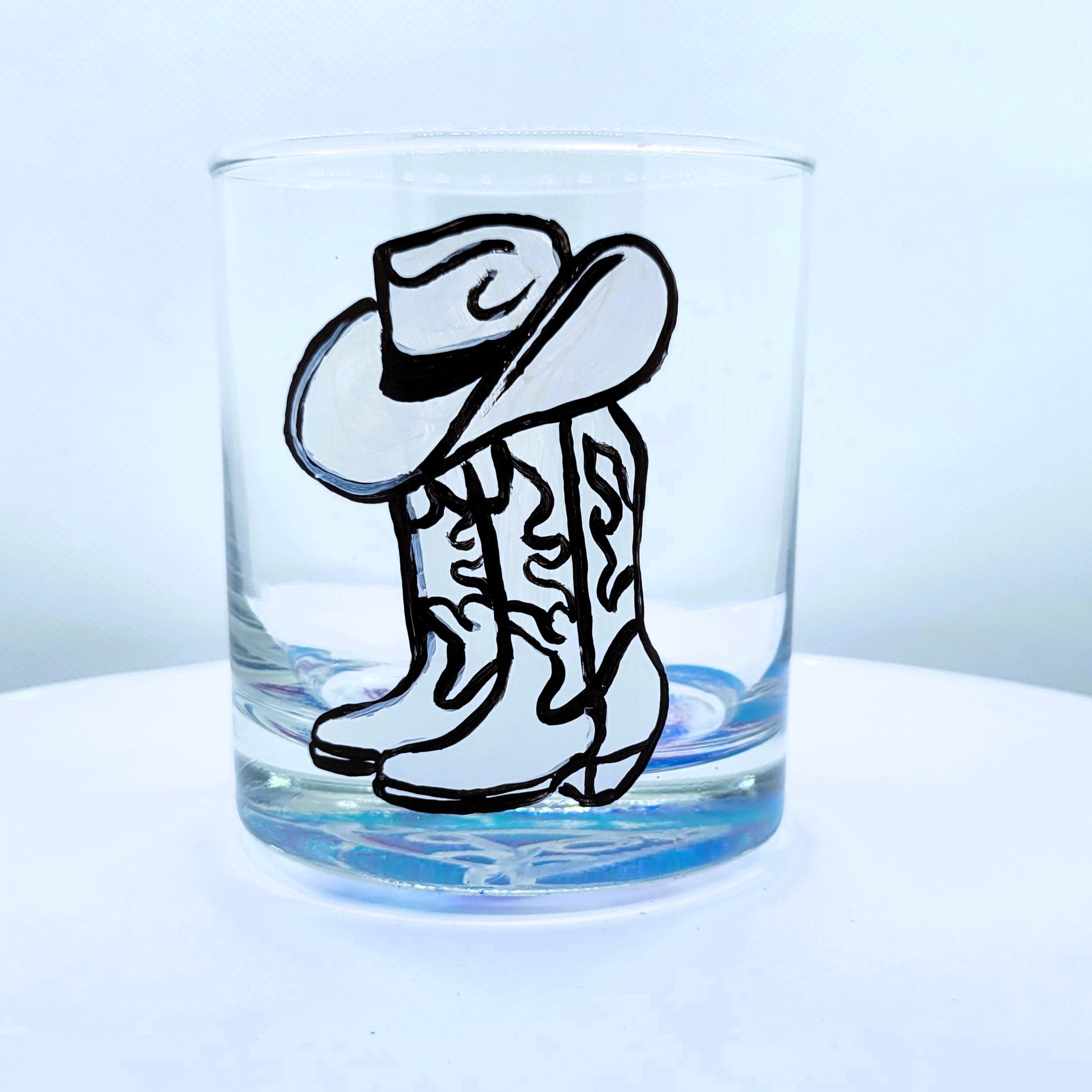 cowboy boots and hat on a short highball whiskey glass