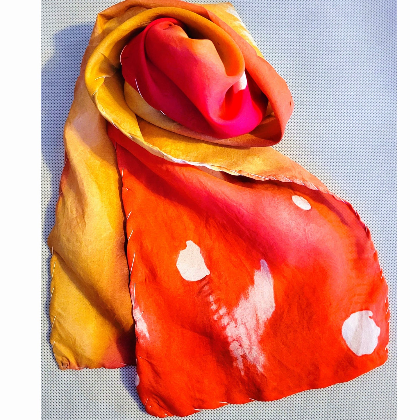 silk scarf swirled showing red with spots and feather texture