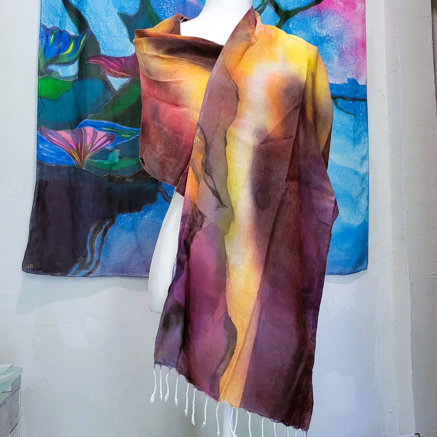 Hand-painted wearable rayon scarf featuring nebula-inspired sunrise colors with subtle black mountain line work by Amy Bridges