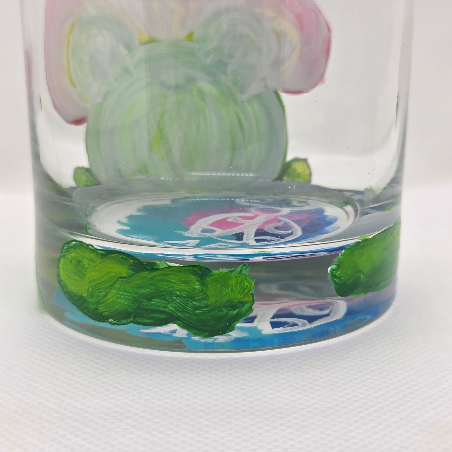 Hand-painted 11 oz highball glass featuring a whimsical frog sitting on a lily pad wearing a red mushroom hat with lily pad details wrapping around the glass.