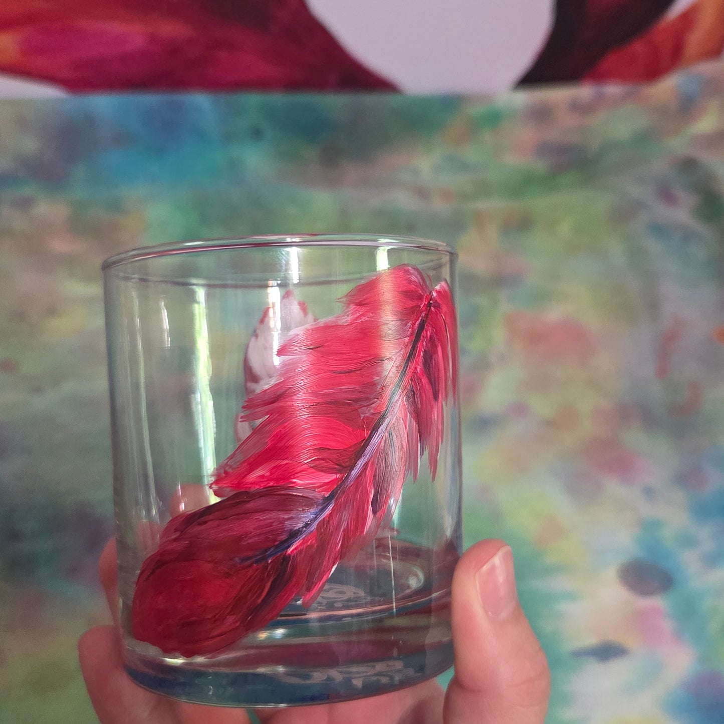 Hand-painted 11 oz short tumbler with two cardinal feathers in red, cobalt blue, and deep purple, one rising and one falling