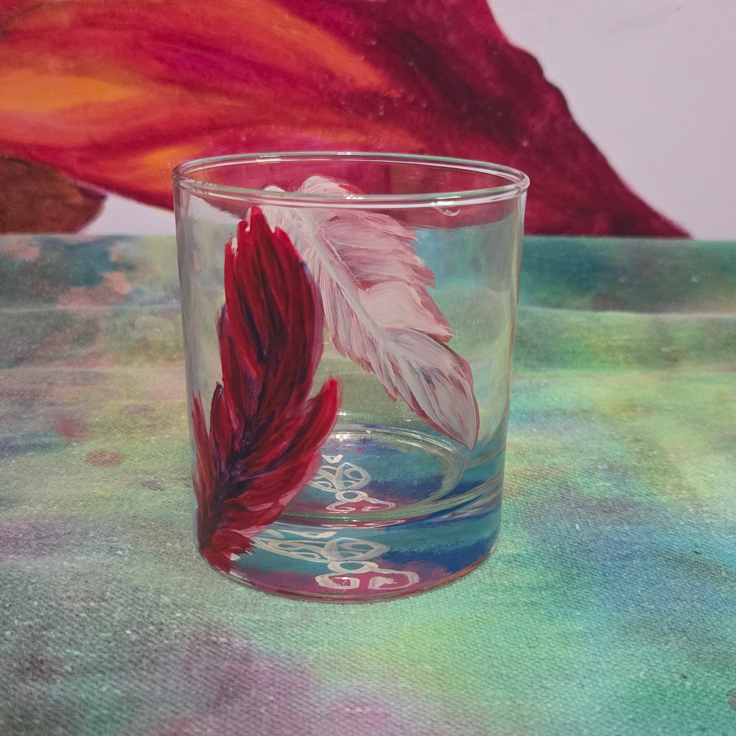 Hand-painted 11 oz short tumbler with two cardinal feathers in red, cobalt blue, and deep purple, one rising and one falling