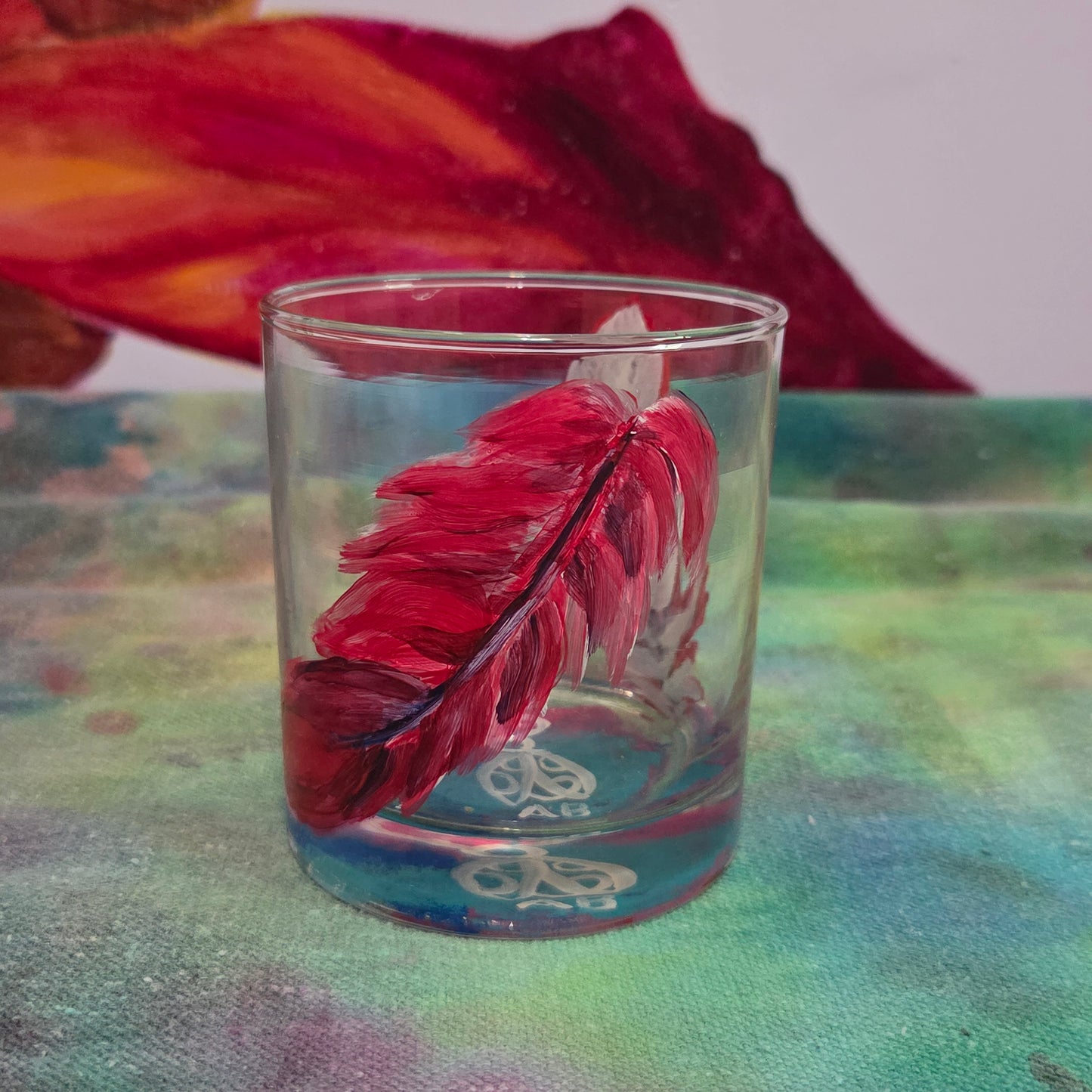 Hand-painted 11 oz short tumbler with two cardinal feathers in red, cobalt blue, and deep purple, one rising and one falling