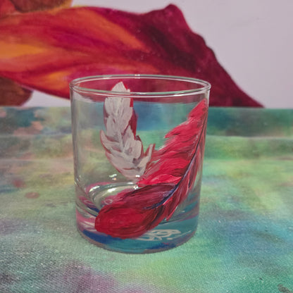 Hand-painted 11 oz short tumbler with two cardinal feathers in red, cobalt blue, and deep purple, one rising and one falling