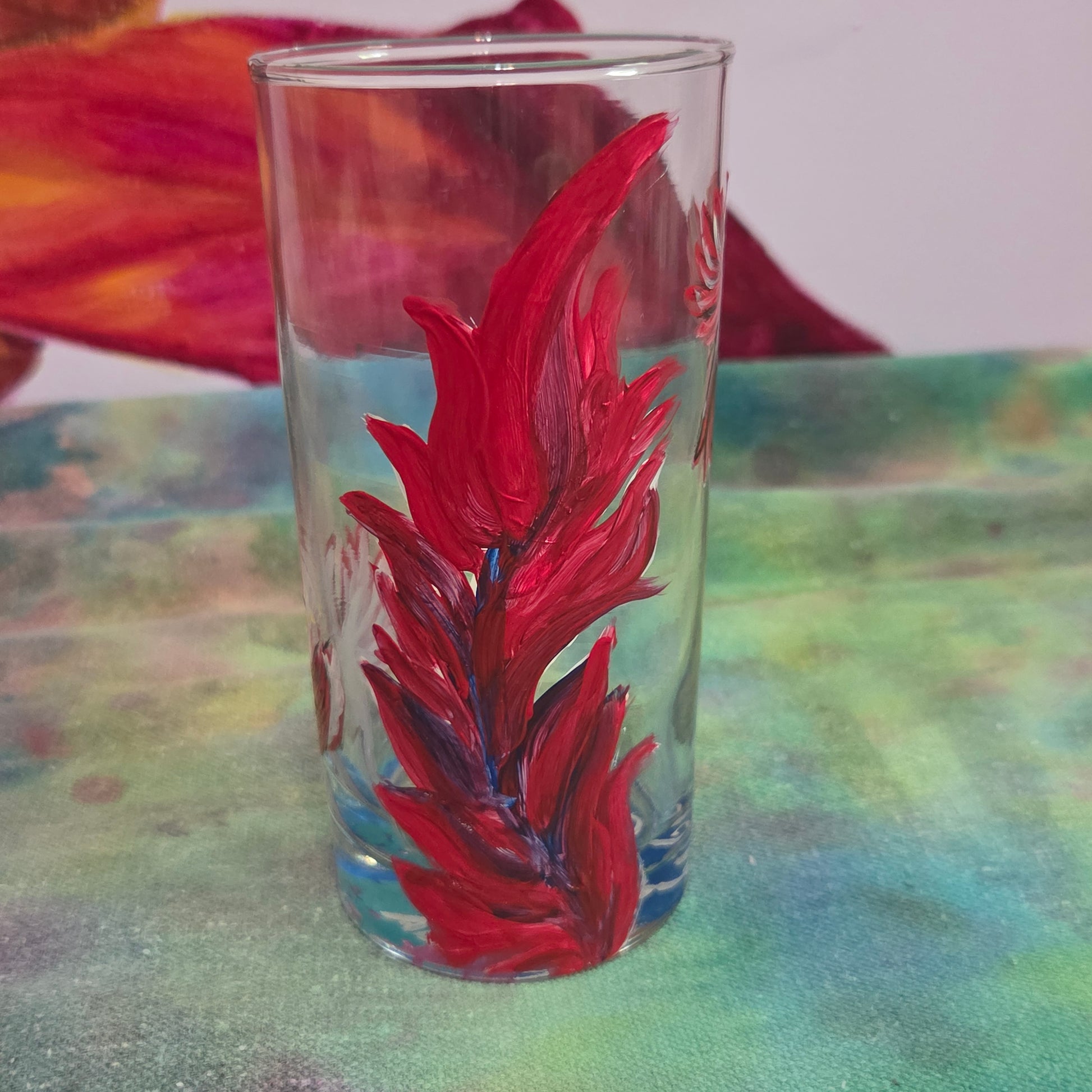 Hand-painted 16 oz tall tumbler with two flying cardinals surrounding a flowing feather