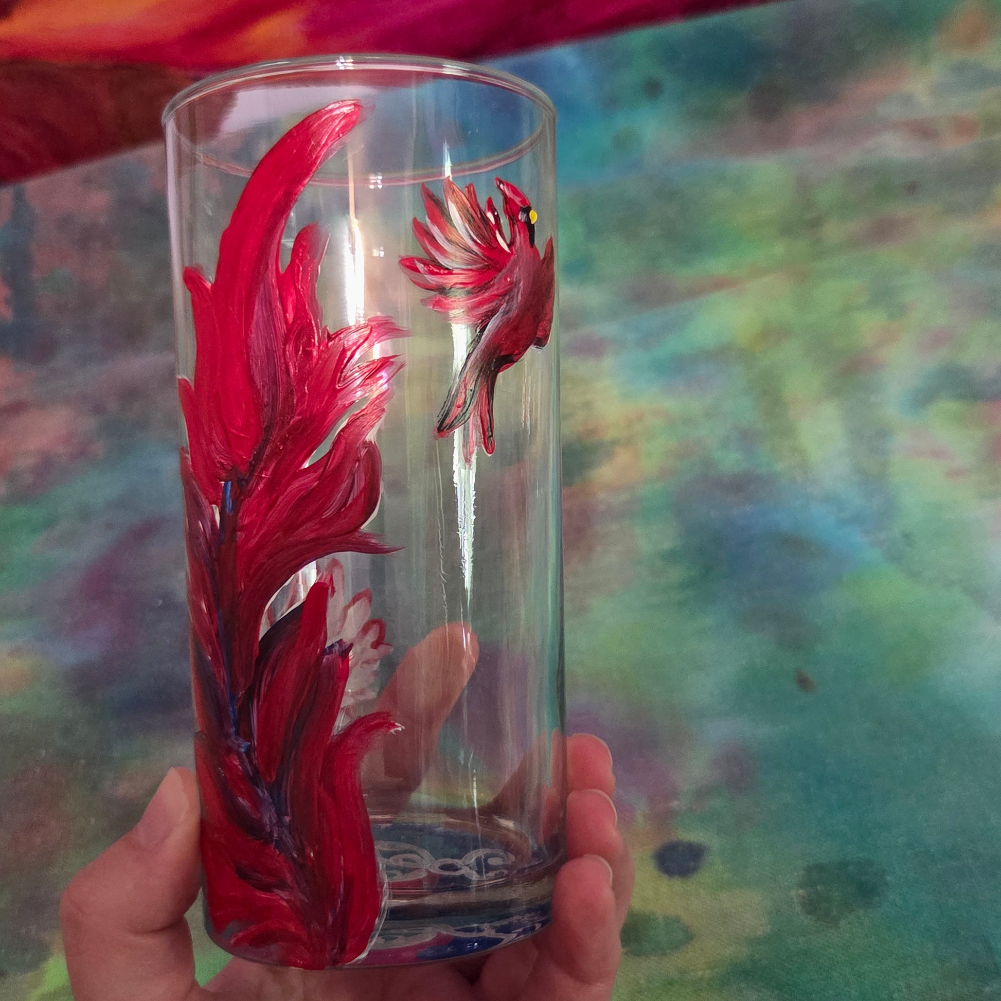 Hand-painted 16 oz tall tumbler with two flying cardinals surrounding a flowing feather