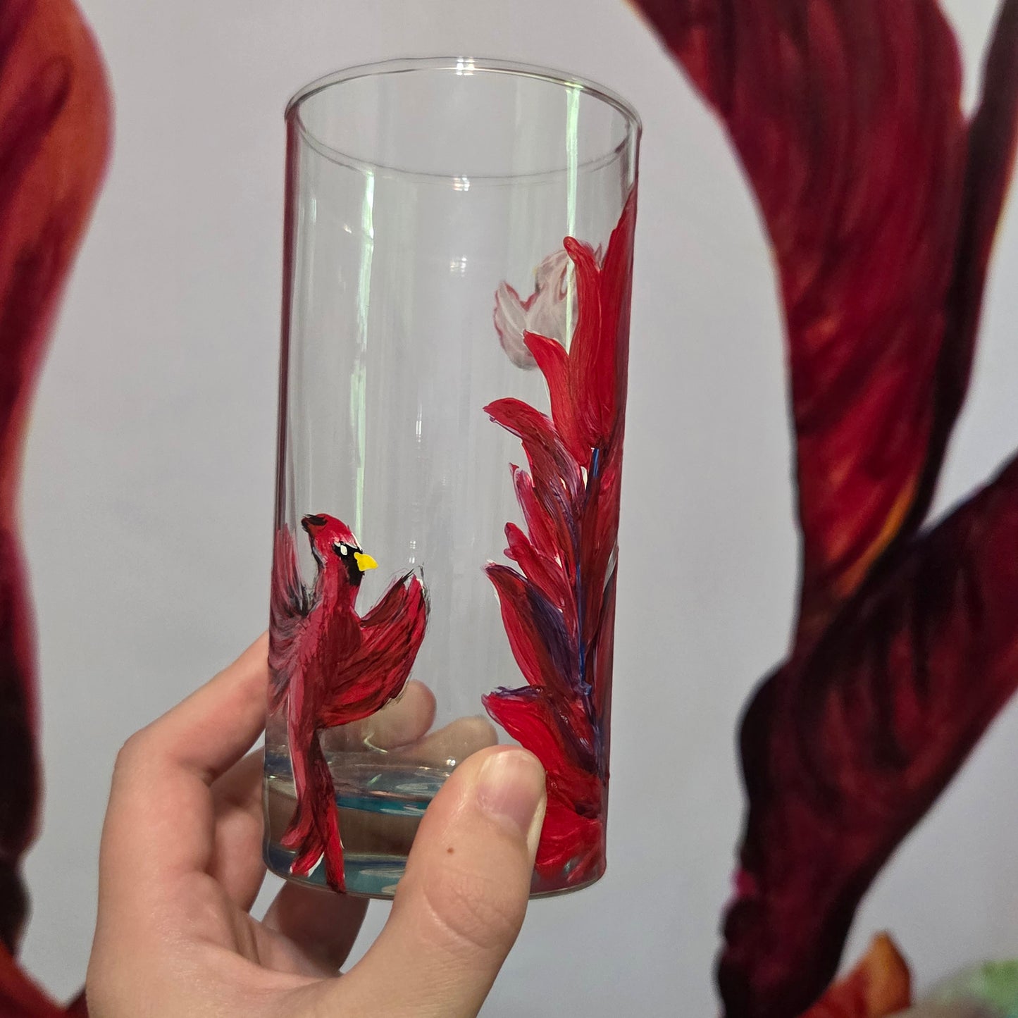 Hand-painted 16 oz tall tumbler with two flying cardinals surrounding a flowing feather