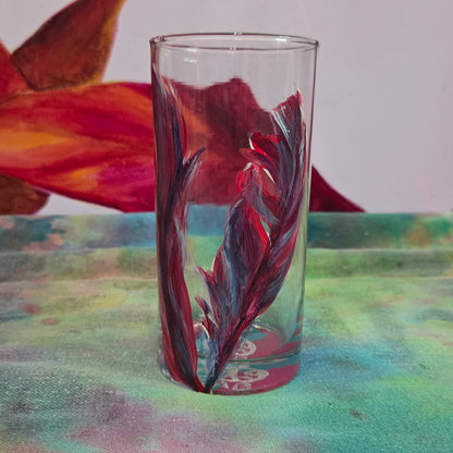 Hand-painted 16 oz tall tumbler with two flowing cardinal feathers in deep red, purple, cobalt blue, and white