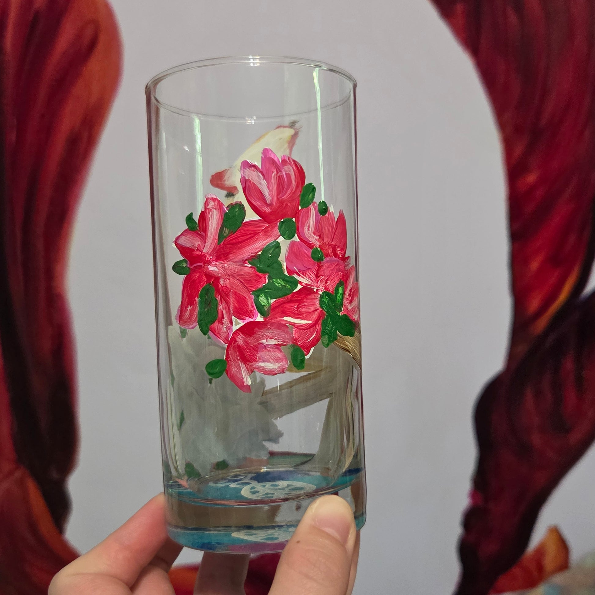 Hand-painted 16 oz tall tumbler with a female cardinal perched on a flowering branch surrounded by red, white, blue, and pink blossoms