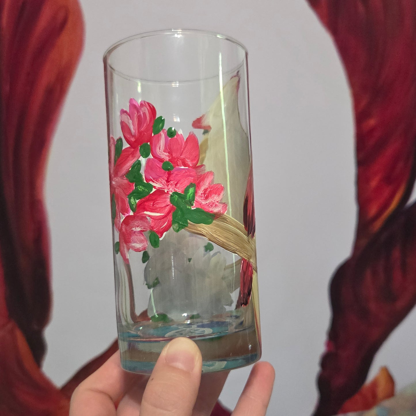 Hand-painted 16 oz tall tumbler with a female cardinal perched on a flowering branch surrounded by red, white, blue, and pink blossoms