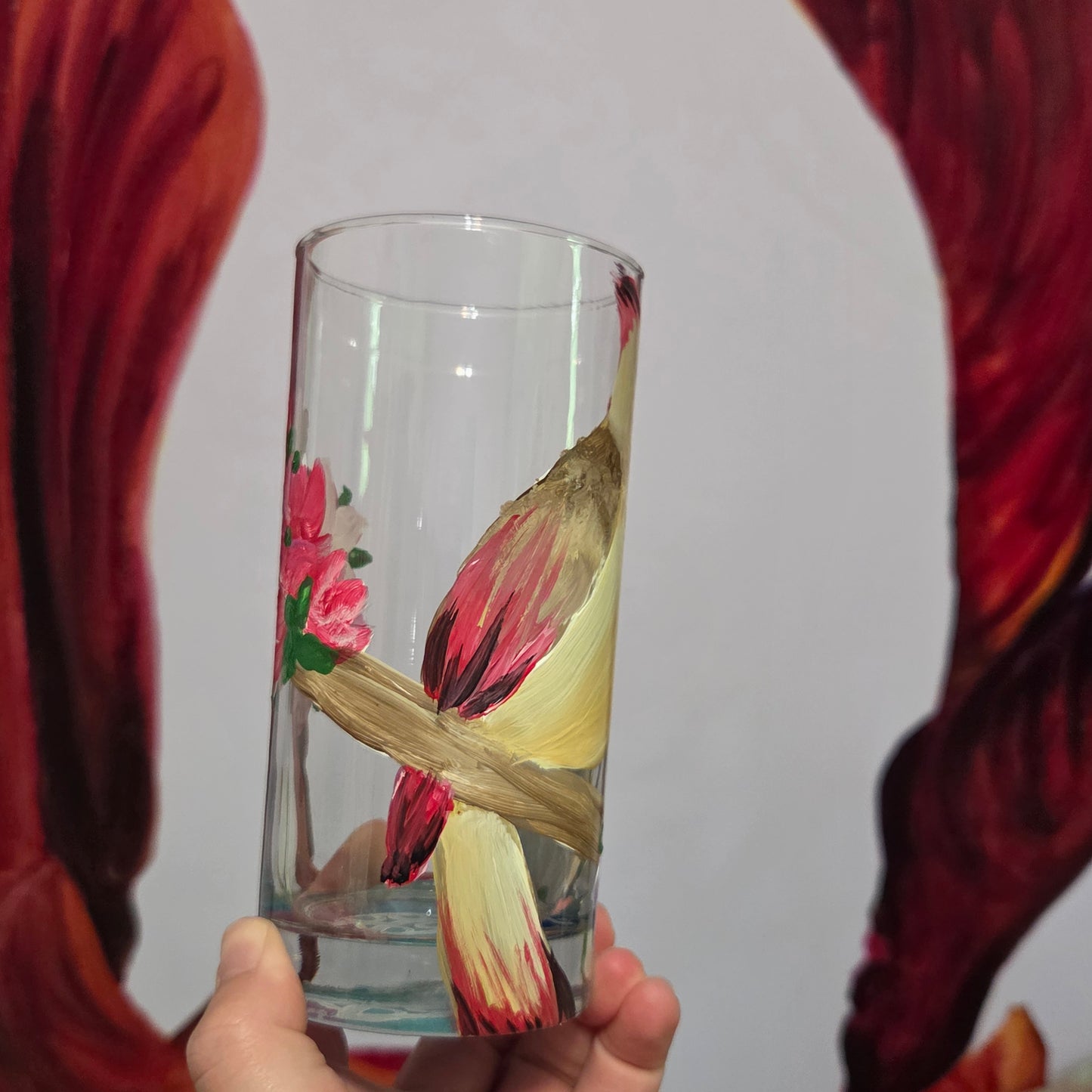 Hand-painted 16 oz tall tumbler with a female cardinal perched on a flowering branch surrounded by red, white, blue, and pink blossoms