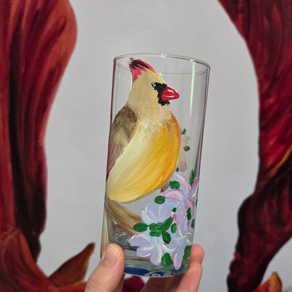 Hand-painted 16 oz tall tumbler with a female cardinal perched on a flowering branch surrounded by red, white, blue, and pink blossoms