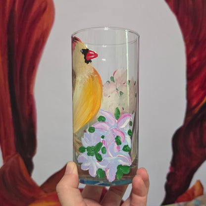 Hand-painted 16 oz tall tumbler with a female cardinal perched on a flowering branch surrounded by red, white, blue, and pink blossoms