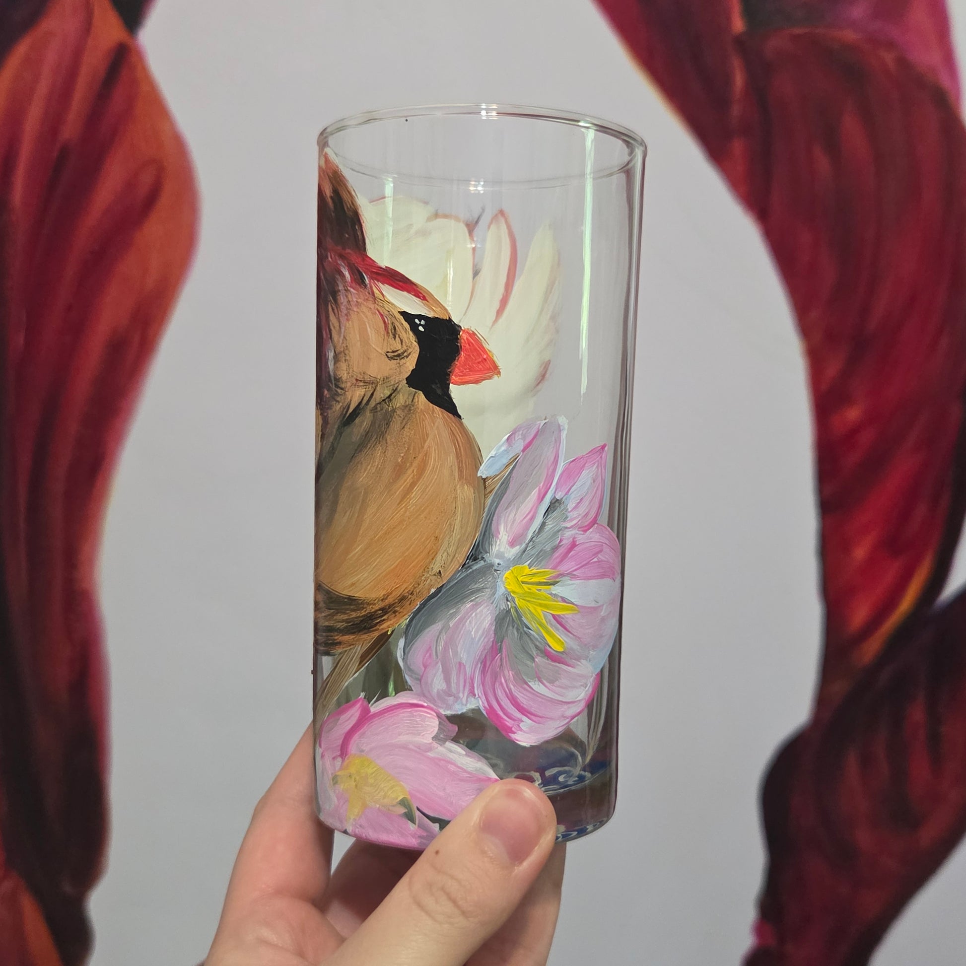 Hand-painted 16 oz tall tumbler with a female cardinal spreading her wings among large pink blossoms
