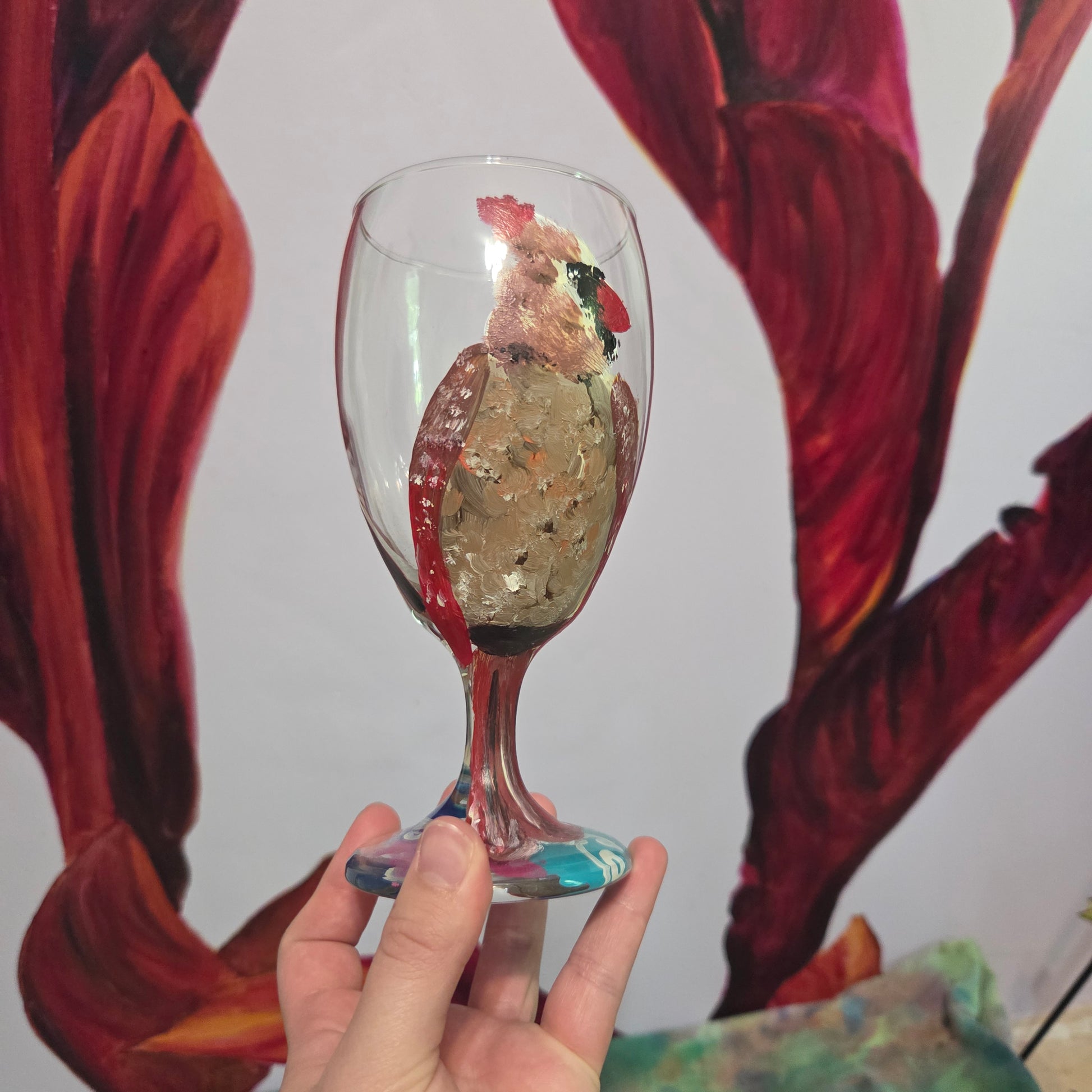 Hand-painted 16 oz goblet with a fluffy female cardinal perched on the bowl and tail feathers extending down the stem