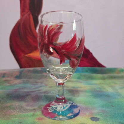 Hand-painted 16 oz goblet with a floating cardinal feather in red, orange, yellow, and subtle black shading