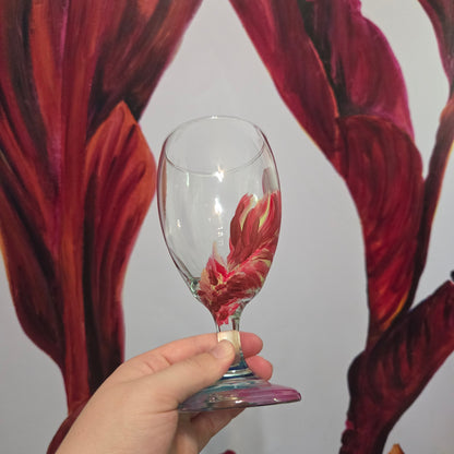 Hand-painted 16 oz glass with a graceful cardinal feather in brilliant red, orange, and golden yellow