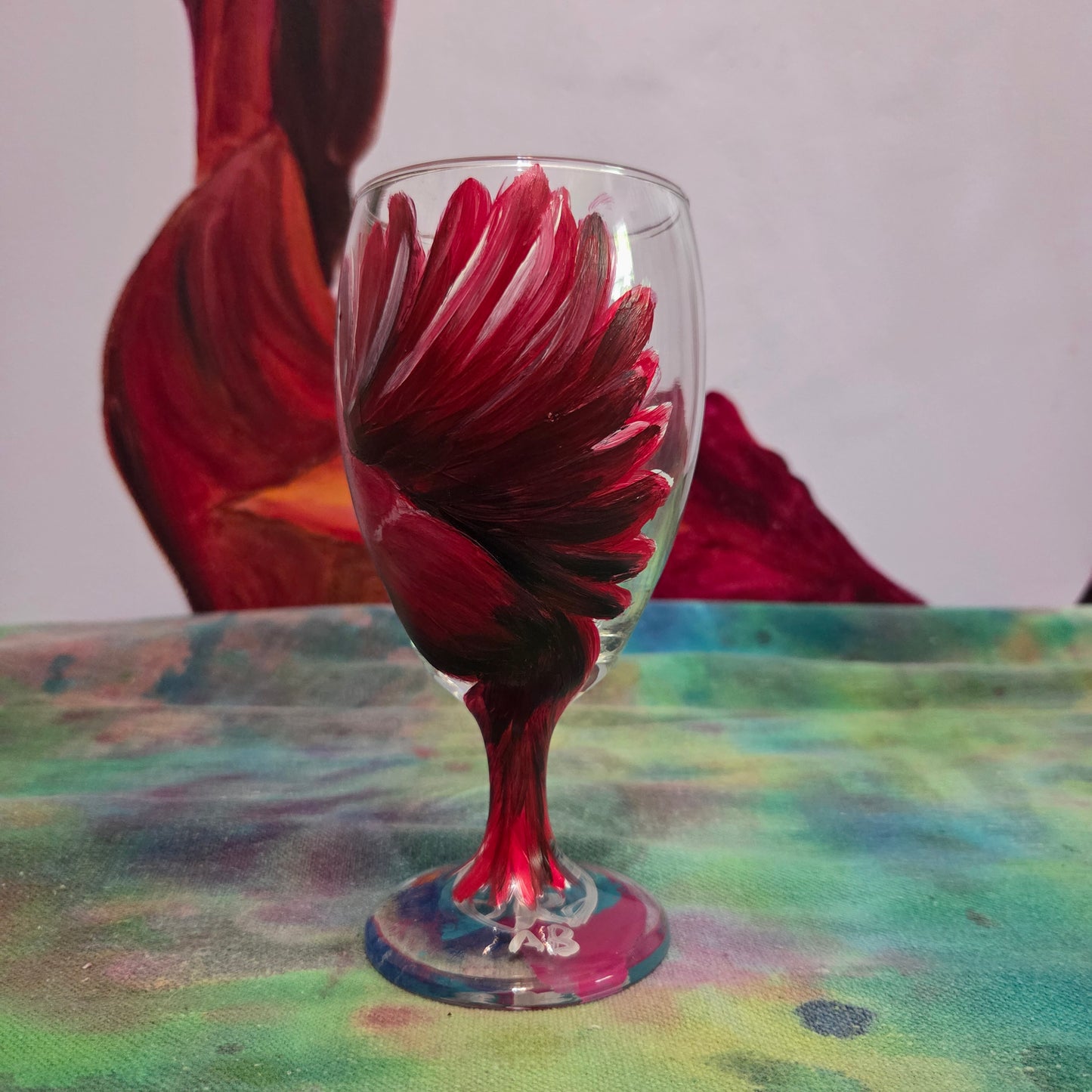 Hand-painted glass featuring a red male cardinal in flight looking down as he approaches his landing perch