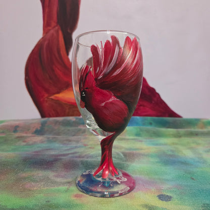 Hand-painted glass featuring a red male cardinal in flight looking down as he approaches his landing perch