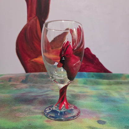 Hand-painted glass featuring a red male cardinal in flight looking down as he approaches his landing perch