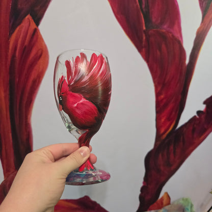 Hand-painted glass featuring a red male cardinal in flight looking down as he approaches his landing perch