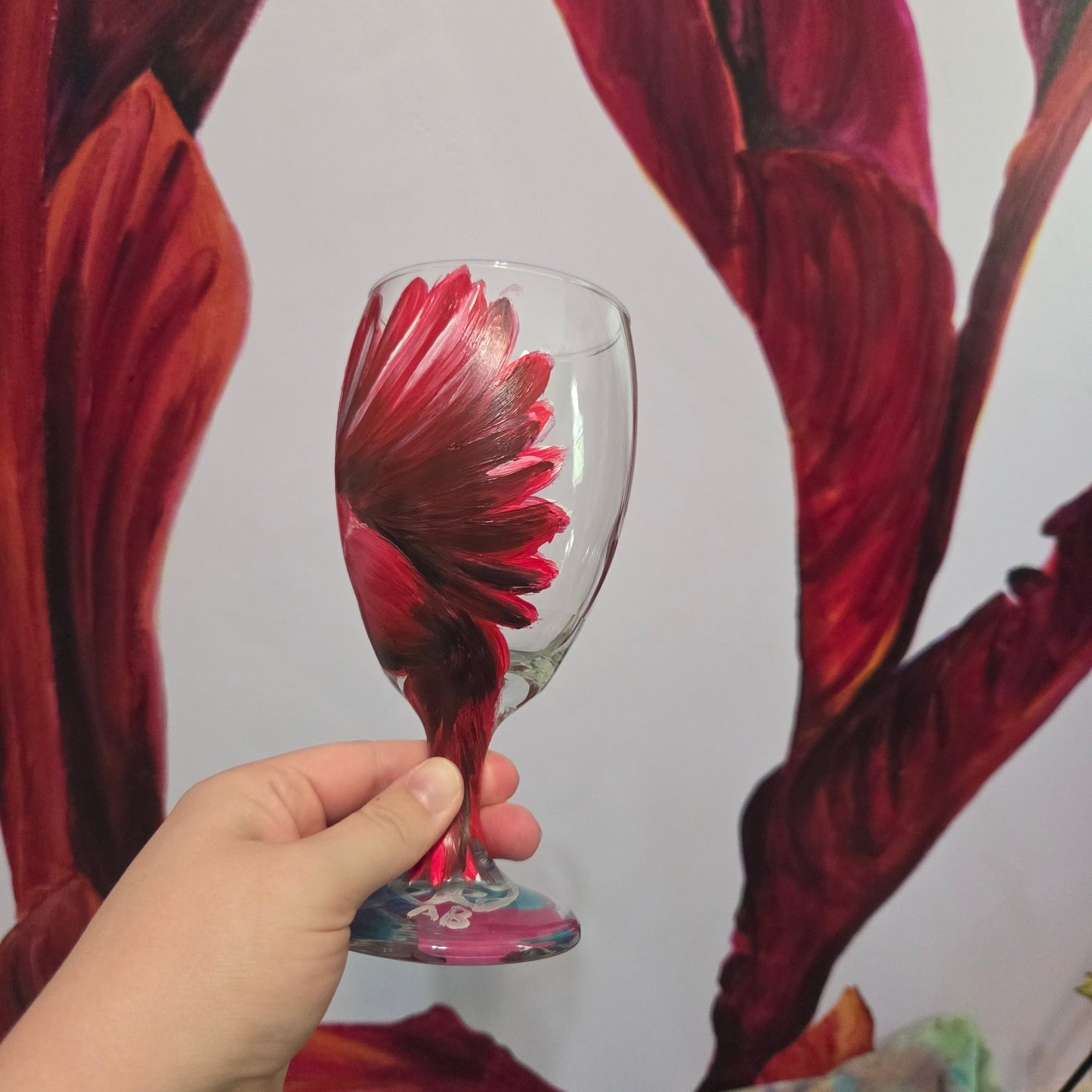 Hand-painted glass featuring a red male cardinal in flight looking down as he approaches his landing perch