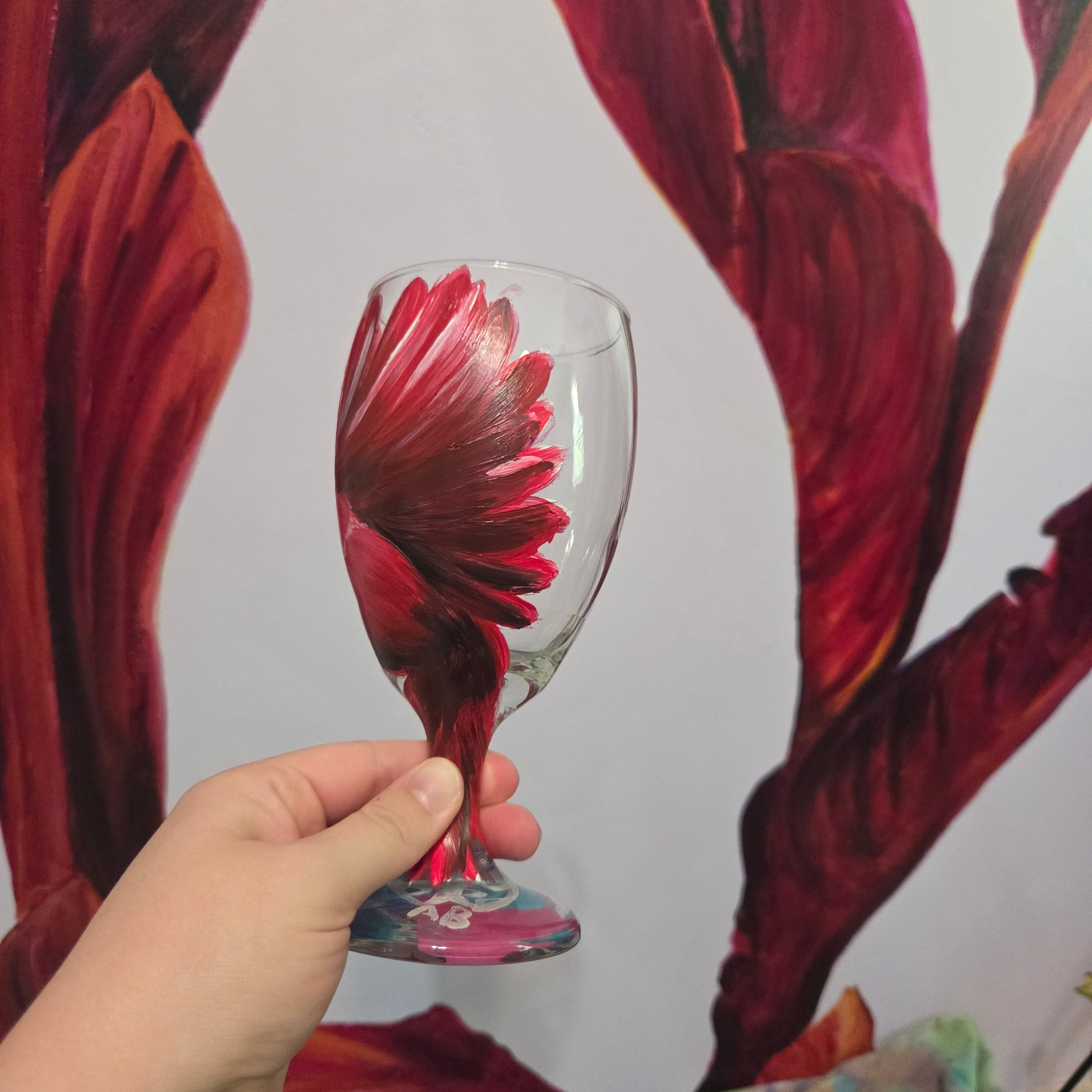 Hand-painted glass featuring a red male cardinal in flight looking down as he approaches his landing perch