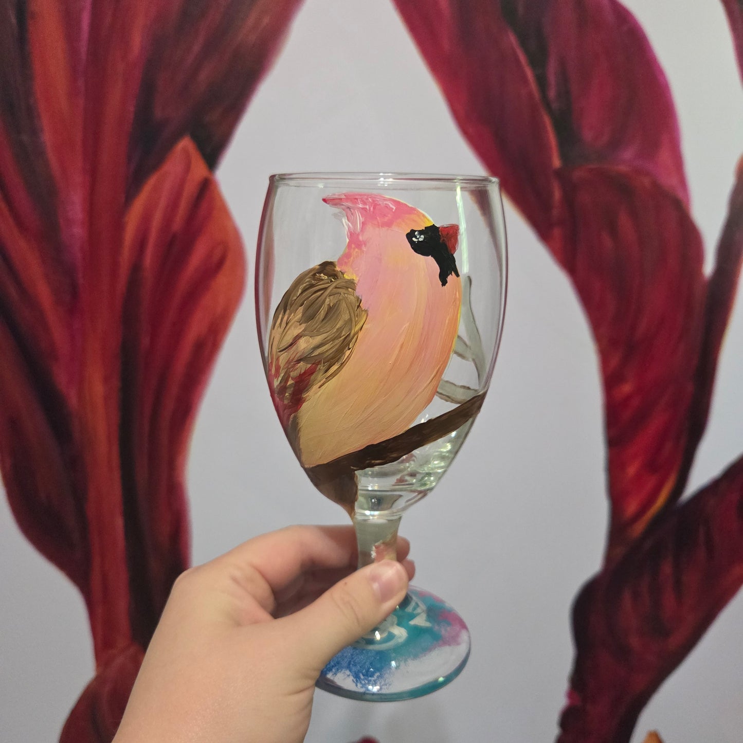 Hand-painted 16 oz glass with a pink-toned female cardinal perched on a branch and looking upward