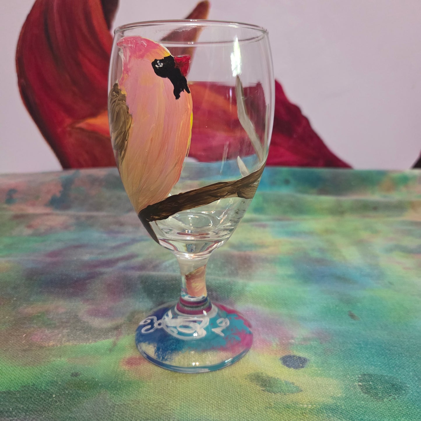 Hand-painted 16 oz glass with a pink-toned female cardinal perched on a branch and looking upward