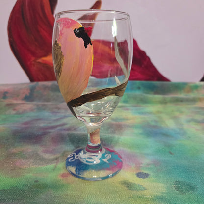Hand-painted 16 oz glass with a pink-toned female cardinal perched on a branch and looking upward