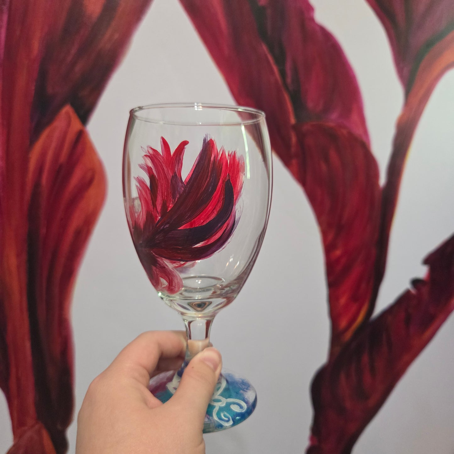 Hand-painted 16 oz goblet with a floating cardinal feather in bold red with black and subtle purple shadows