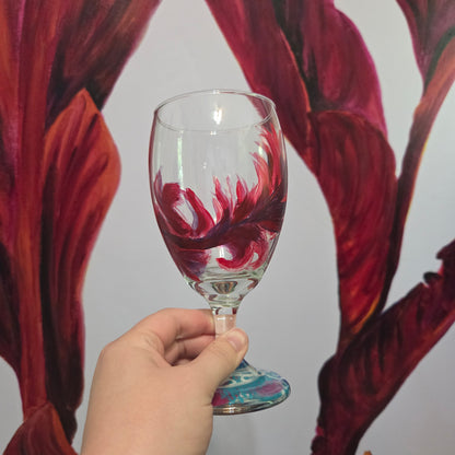 Hand-painted 16 oz goblet with a floating cardinal feather in bold red with black and subtle purple shadows