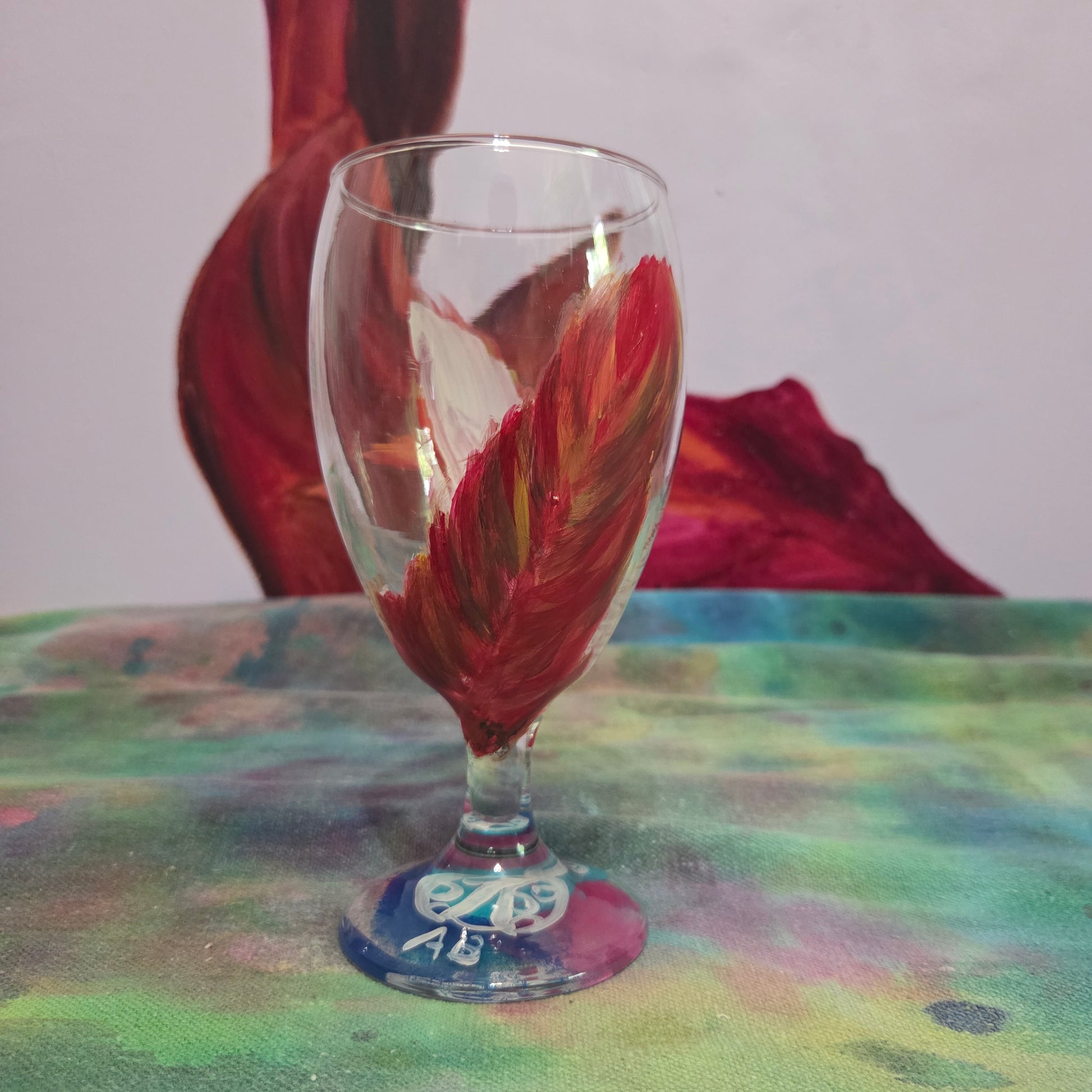 Hand-painted 16 oz goblet with two upright cardinal feathers in red, orange, and golden yellow
