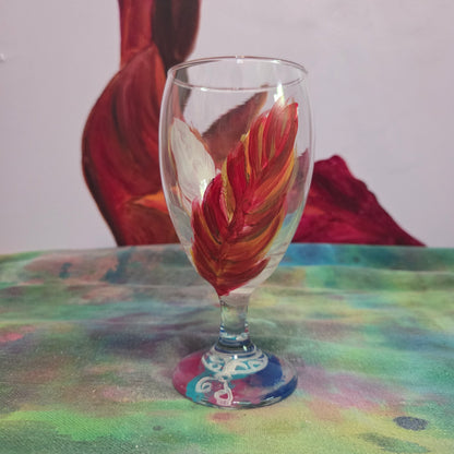 Hand-painted 16 oz goblet with two upright cardinal feathers in red, orange, and golden yellow