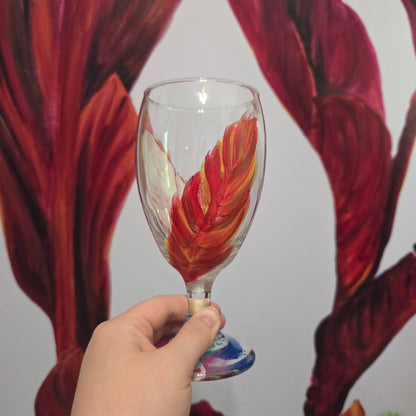 Hand-painted 16 oz goblet with two upright cardinal feathers in red, orange, and golden yellow