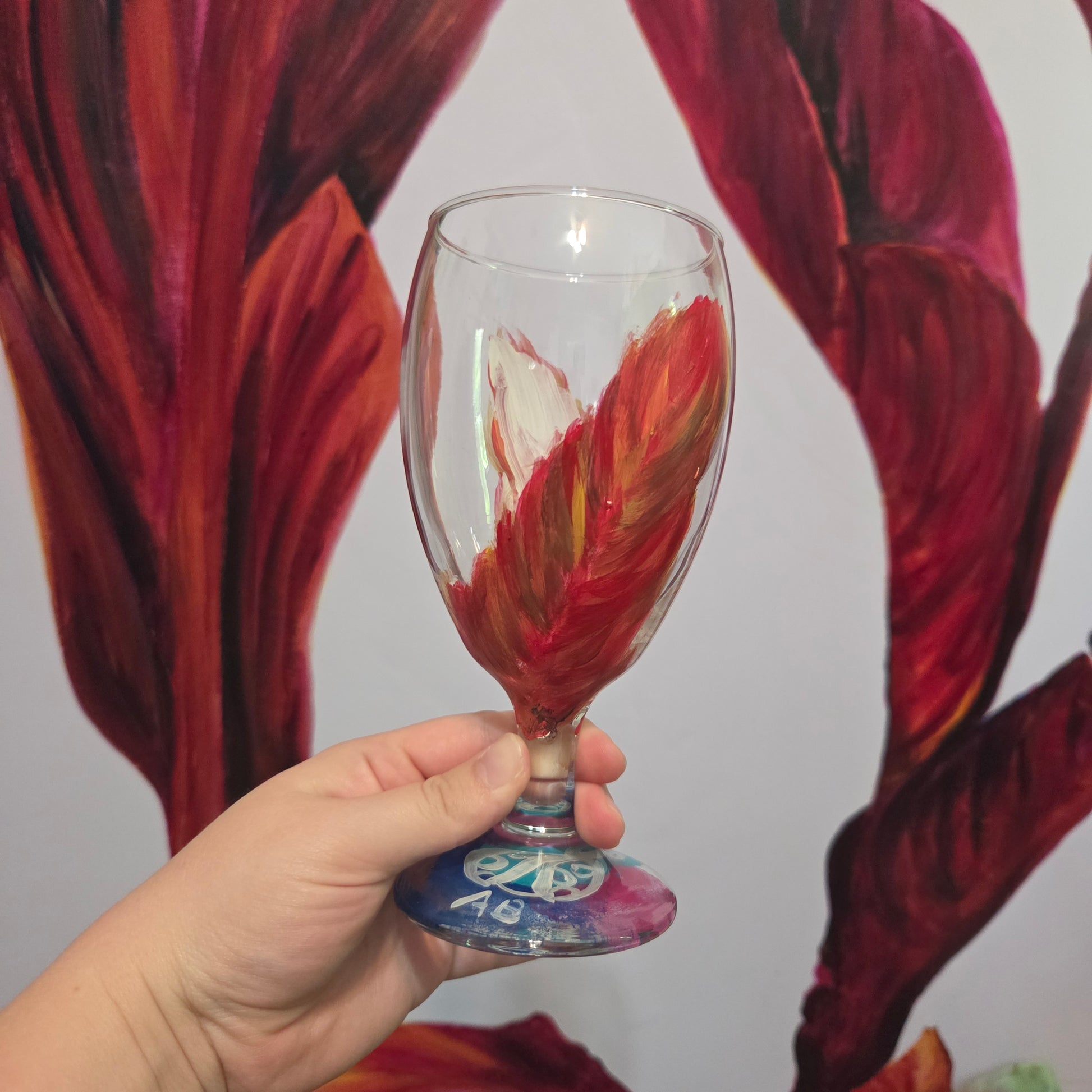 Hand-painted 16 oz goblet with two upright cardinal feathers in red, orange, and golden yellow