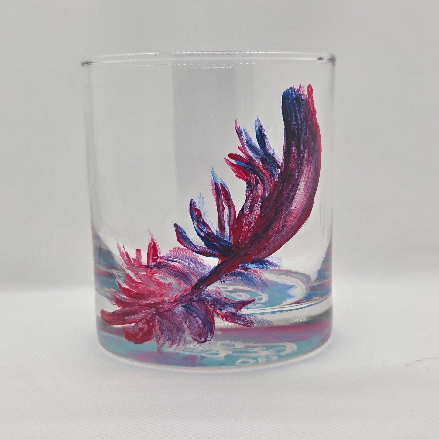 Hand-painted 11 oz short tumbler with a drifting cardinal feather in red, cobalt blue, and deep purple