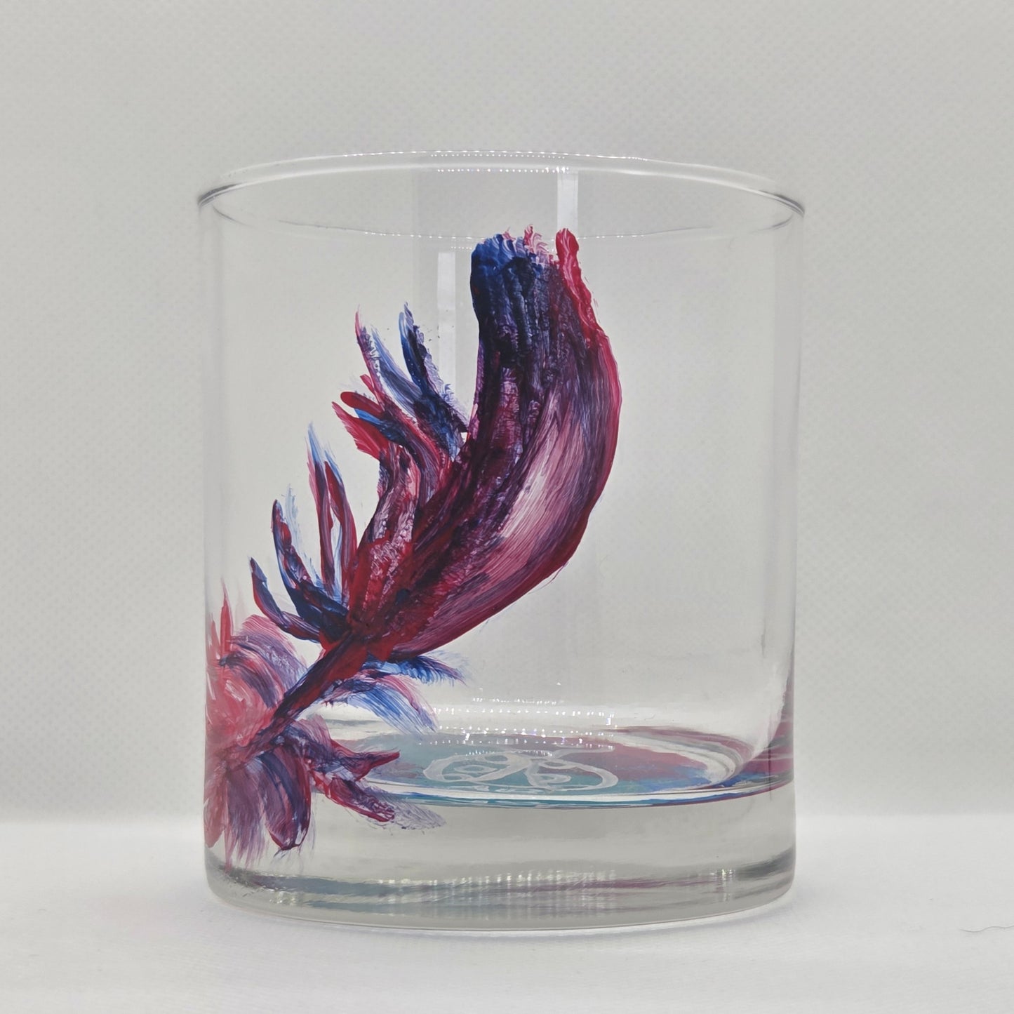 Hand-painted 11 oz short tumbler with a drifting cardinal feather in red, cobalt blue, and deep purple
