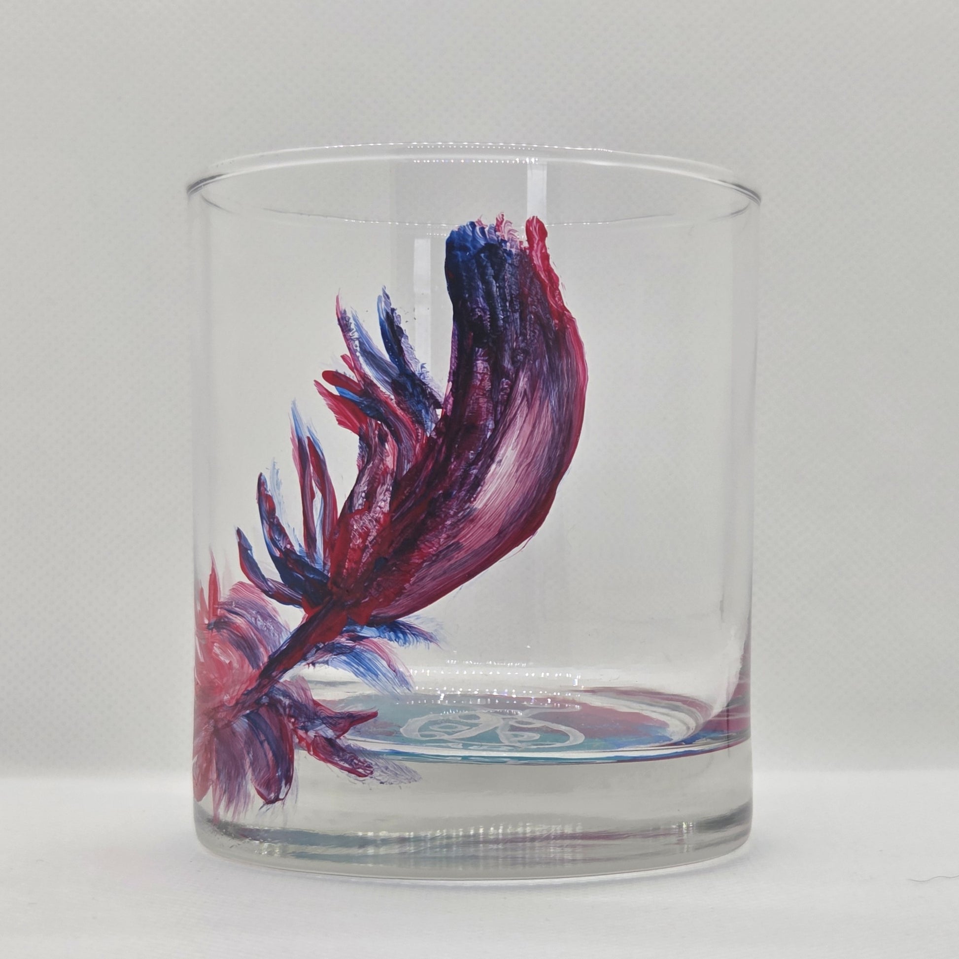 Hand-painted 11 oz short tumbler with a drifting cardinal feather in red, cobalt blue, and deep purple