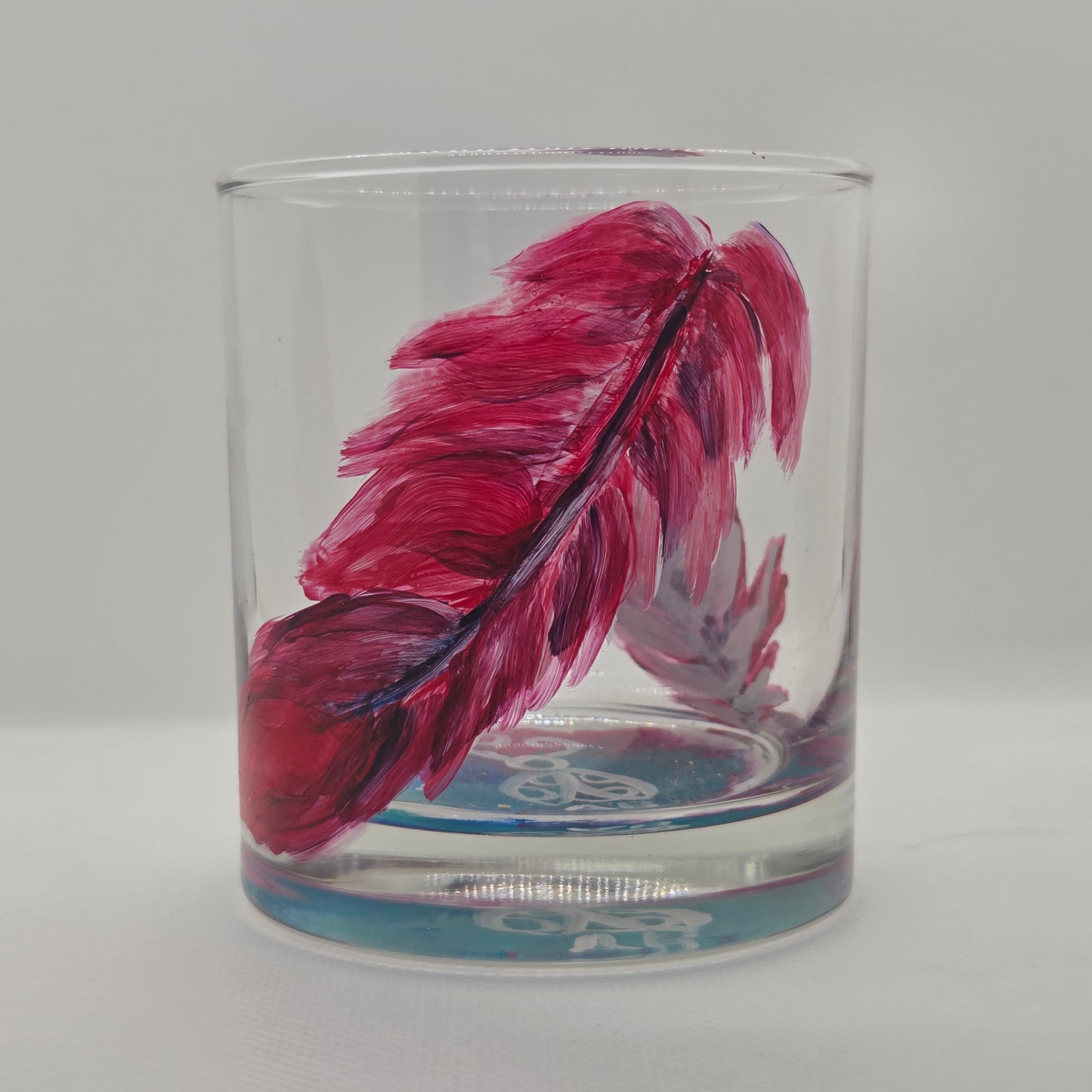 Hand-painted 11 oz short tumbler with two cardinal feathers in red, cobalt blue, and deep purple, one rising and one falling