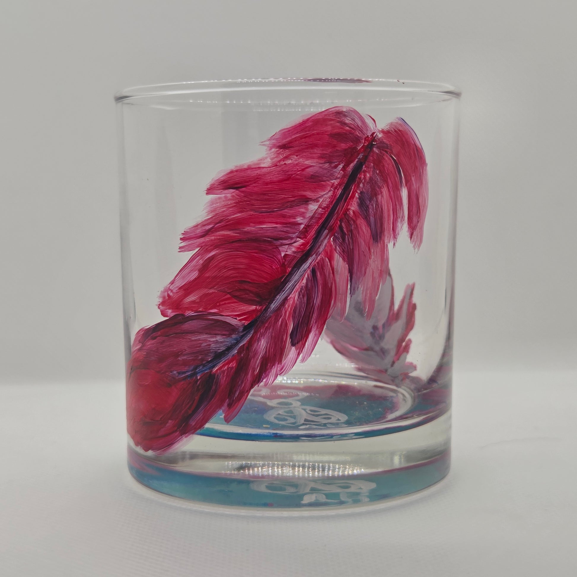 Hand-painted 11 oz short tumbler with two cardinal feathers in red, cobalt blue, and deep purple, one rising and one falling