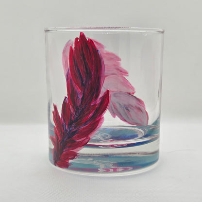 Hand-painted 11 oz short tumbler with two cardinal feathers in red, cobalt blue, and deep purple, one rising and one falling