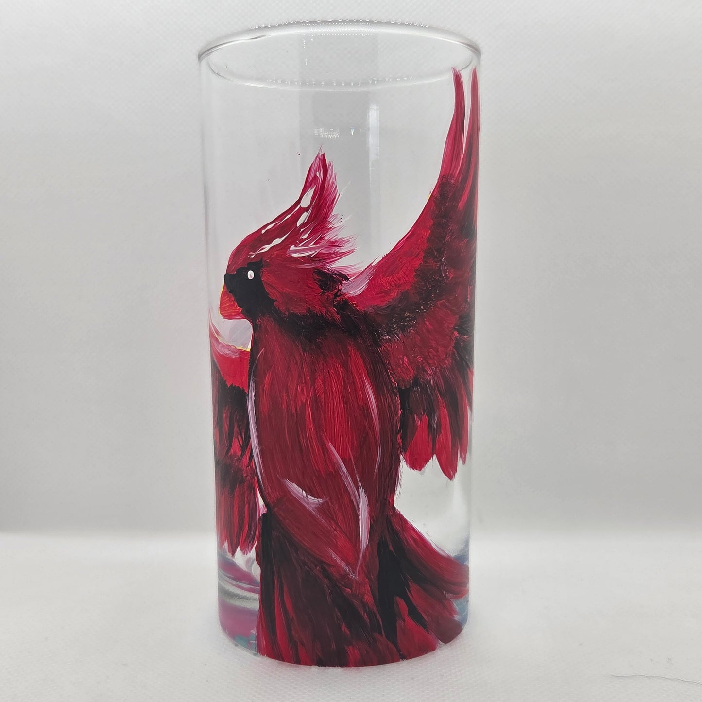 Hand-painted 16 oz tumbler featuring a bold red cardinal facing forward with wings spread wide