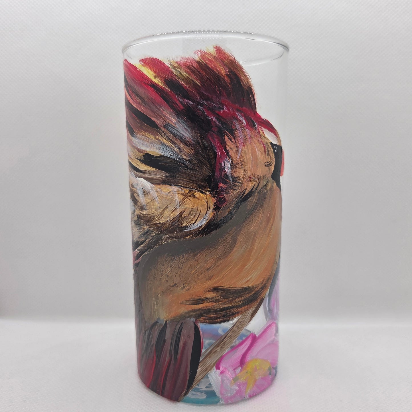 Hand-painted 16 oz tall tumbler with a female cardinal spreading her wings among large pink blossoms