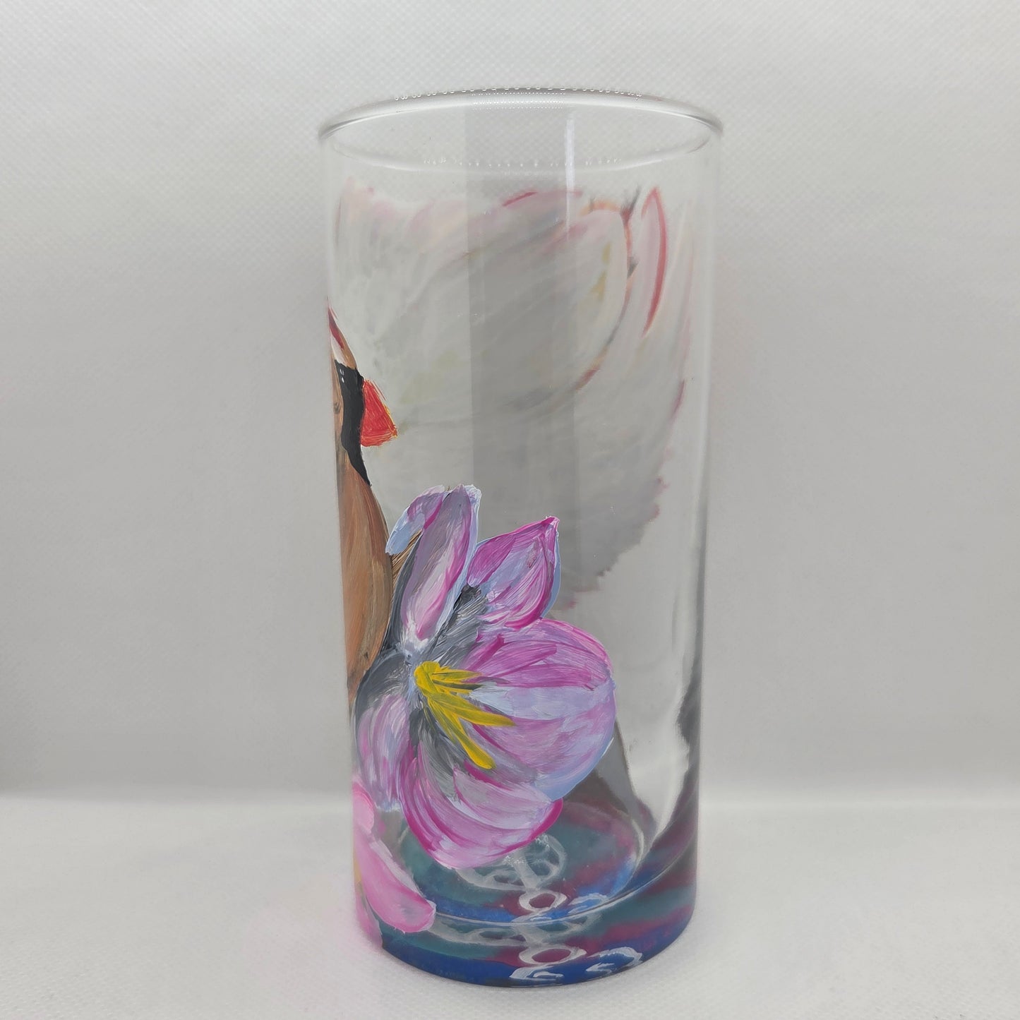 Hand-painted 16 oz tall tumbler with a female cardinal spreading her wings among large pink blossoms