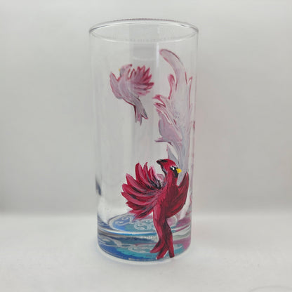 Hand-painted 16 oz tall tumbler with two flying cardinals surrounding a flowing feather