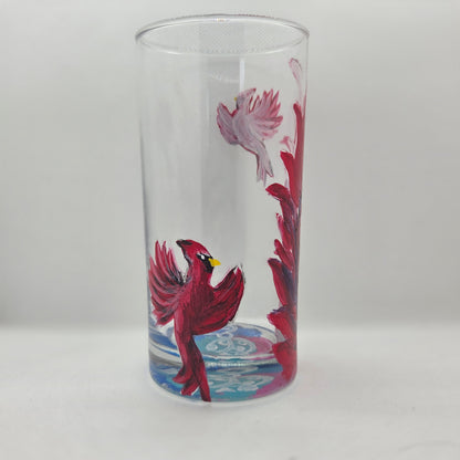 Hand-painted 16 oz tall tumbler with two flying cardinals surrounding a flowing feather
